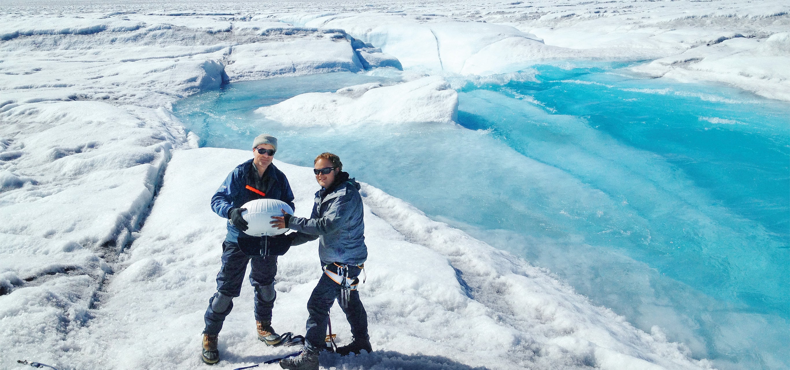 Professor Laurence C. Smith poses with a fellow researcher on a glacier in Greenland.